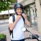 handsome young man in a modern city adjusting motorcycle helmet in summer